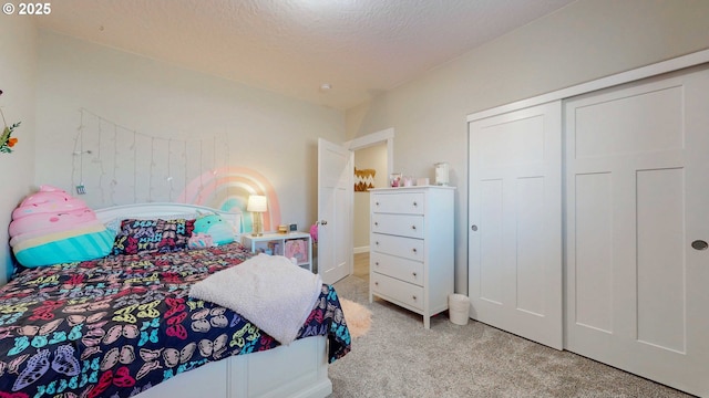 carpeted bedroom featuring a textured ceiling and a closet