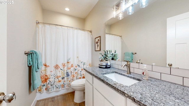 bathroom with tasteful backsplash, toilet, shower / bath combo, vanity, and wood finished floors