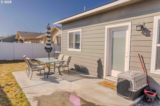 view of patio featuring ac unit, outdoor dining area, and fence