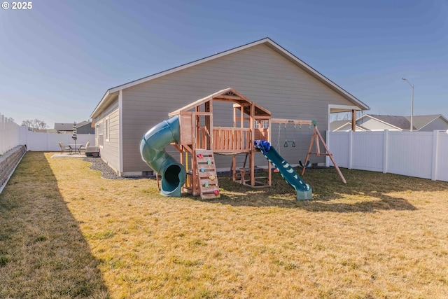 view of playground with a patio area, a fenced backyard, and a lawn