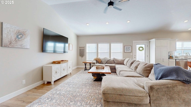 living area with light wood-type flooring, baseboards, and recessed lighting