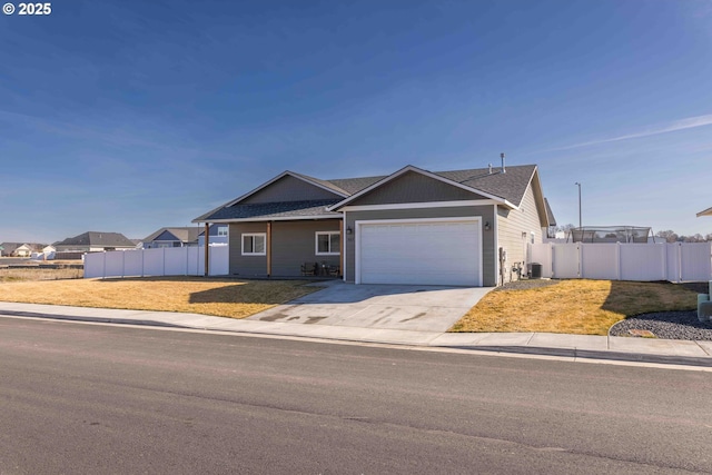 ranch-style home with a front lawn, fence, driveway, and an attached garage