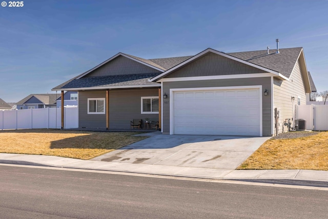 ranch-style home featuring central air condition unit, a front yard, fence, a garage, and driveway