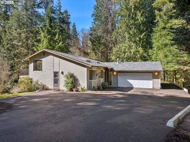 mid-century home featuring driveway and an attached garage