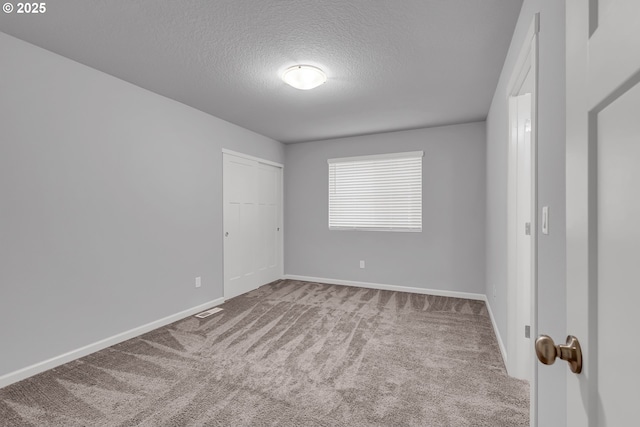 1618 36th Pl, Forest Grove, OR 97116 - unfurnished bedroom with carpet flooring, a textured ceiling, baseboards, and a closet