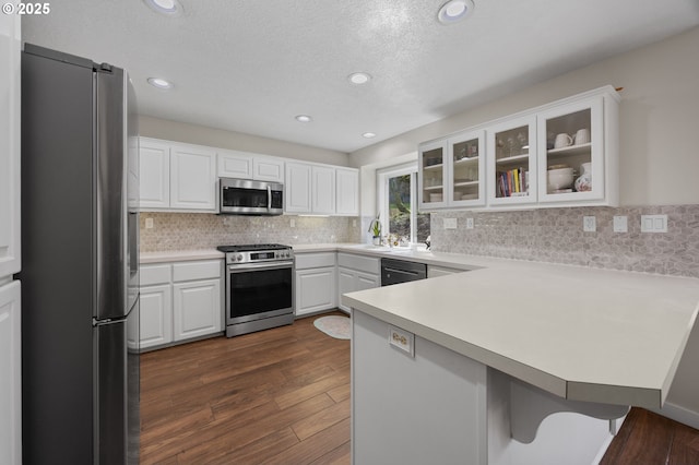 9435 SE 282nd Ave, Boring, OR 97009 - kitchen with appliances with stainless steel finishes, a peninsula, glass insert cabinets, tasteful backsplash, and white cabinetry