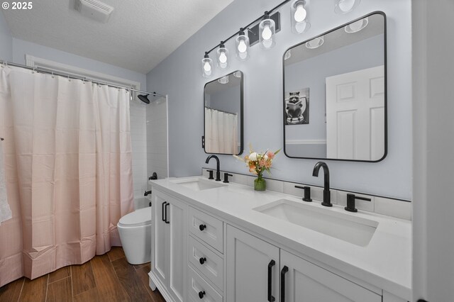 9435 SE 282nd Ave, Boring, OR 97009 - full bathroom with double vanity, wood finished floors, shower / tub combo with curtain, and a textured ceiling
