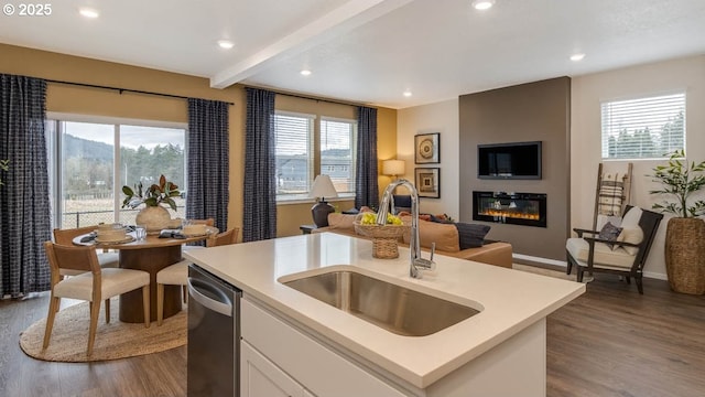 kitchen with a fireplace, a sink, open floor plan, light countertops, and dishwasher