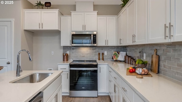 kitchen featuring white cabinetry, appliances with stainless steel finishes, light countertops, and a sink