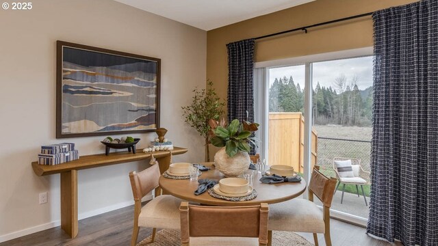 dining space with baseboards and wood finished floors