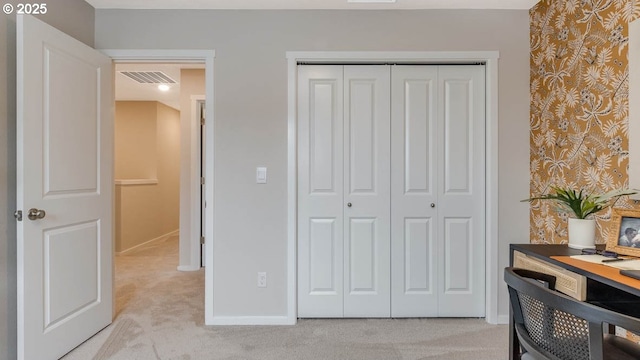 bedroom with a closet, light colored carpet, visible vents, baseboards, and wallpapered walls