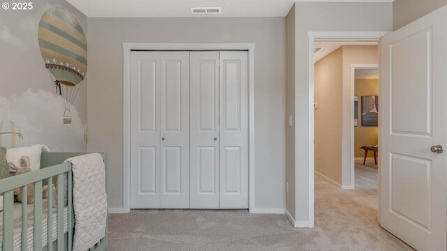 unfurnished bedroom featuring light carpet, a closet, and baseboards