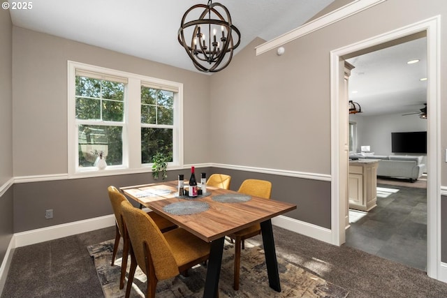 dining room with ceiling fan with notable chandelier, baseboards, vaulted ceiling, and dark colored carpet