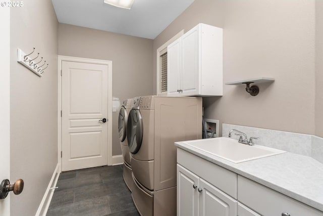 washroom with separate washer and dryer, a sink, cabinet space, and baseboards