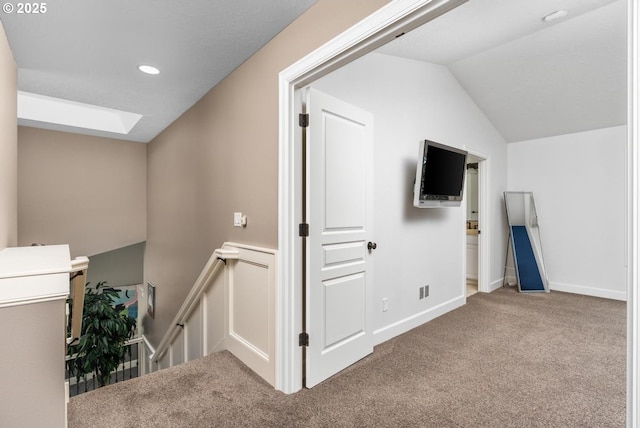 interior space with carpet floors, lofted ceiling with skylight, baseboards, and recessed lighting