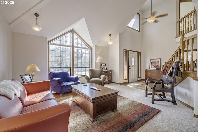 living room with high vaulted ceiling, baseboards, light colored carpet, and stairs