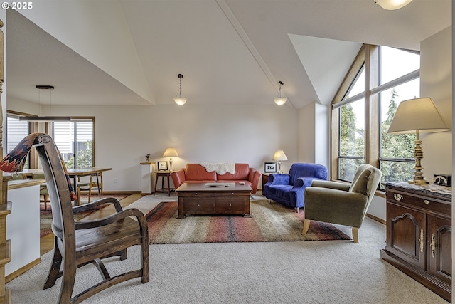 living room featuring baseboards, light carpet, and lofted ceiling