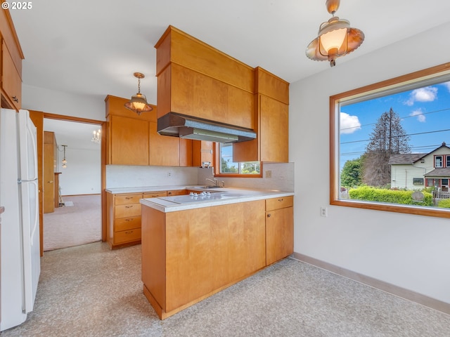 4915 Leif Erikson Dr, Astoria, OR 97103 - kitchen featuring under cabinet range hood, freestanding refrigerator, light countertops, a sink, and a peninsula