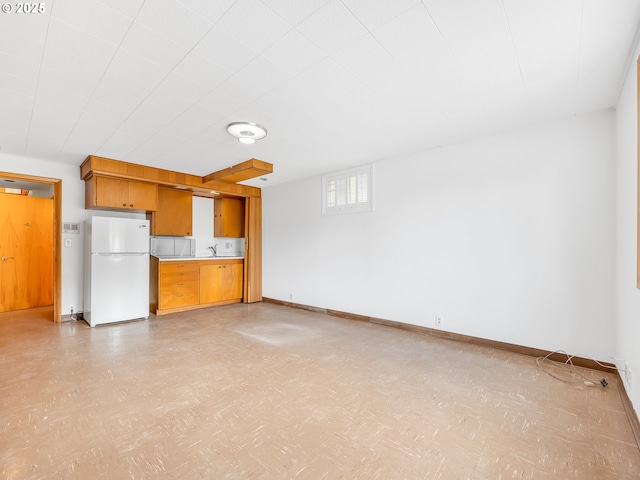 4915 Leif Erikson Dr, Astoria, OR 97103 - unfurnished living room featuring light flooring, baseboards, and a sink