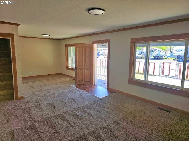 967 NW 2nd St, Prineville, OR 97754 - foyer with light colored carpet, ornamental molding, and healthy amount of natural light