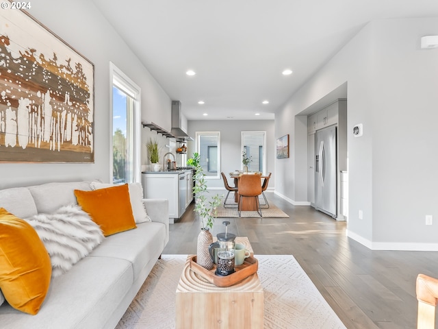 living area featuring baseboards, wood finished floors, and recessed lighting