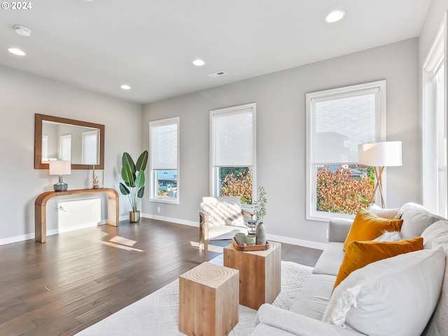 living area featuring plenty of natural light, visible vents, dark wood-type flooring, and recessed lighting