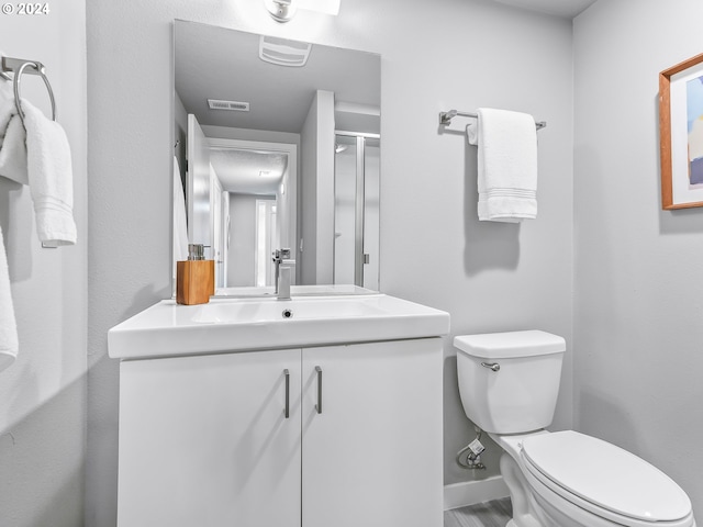 bathroom featuring toilet, baseboards, visible vents, and vanity