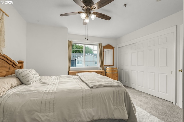 carpeted bedroom featuring ceiling fan and a closet