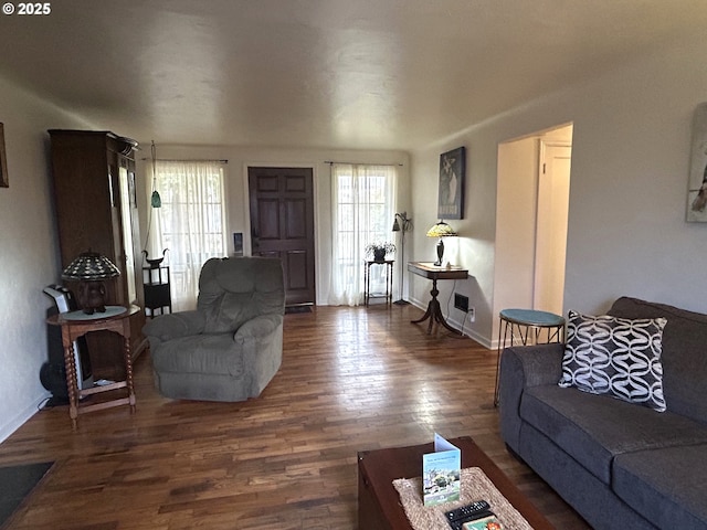 living room with dark wood-type flooring and plenty of natural light