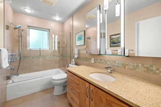 full bathroom featuring tile patterned flooring, toilet, backsplash, tub / shower combination, and vanity