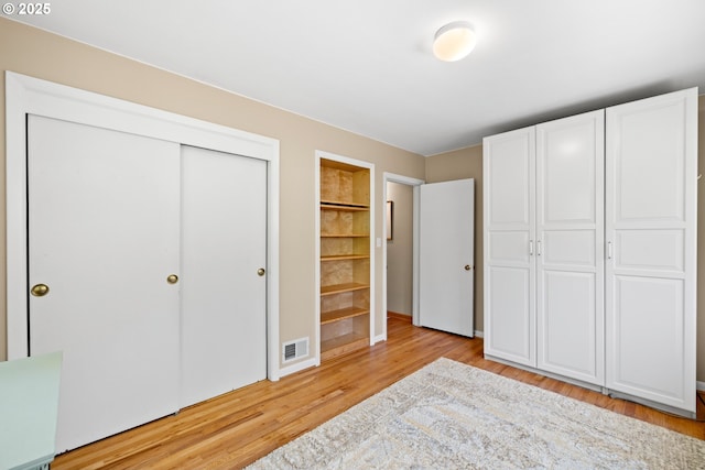 unfurnished bedroom with light wood-type flooring and a closet