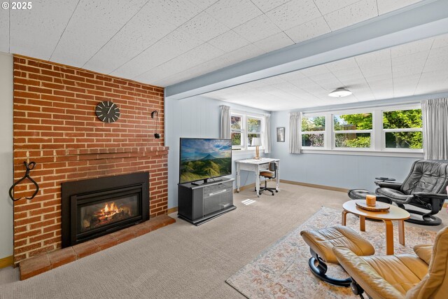 living room featuring a fireplace, carpet, and baseboards