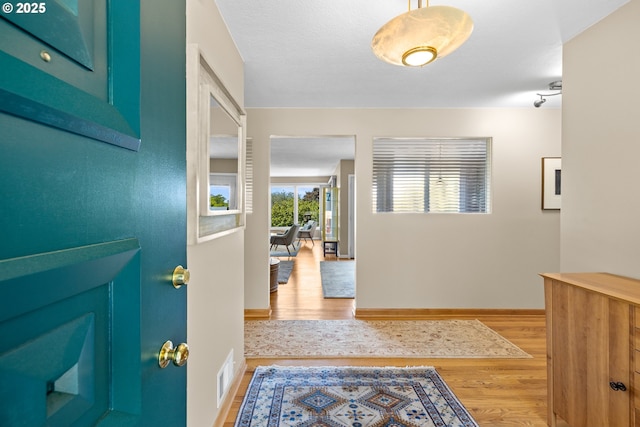hallway with light wood-style floors and baseboards