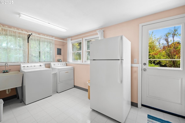 laundry area with washing machine and dryer and baseboards