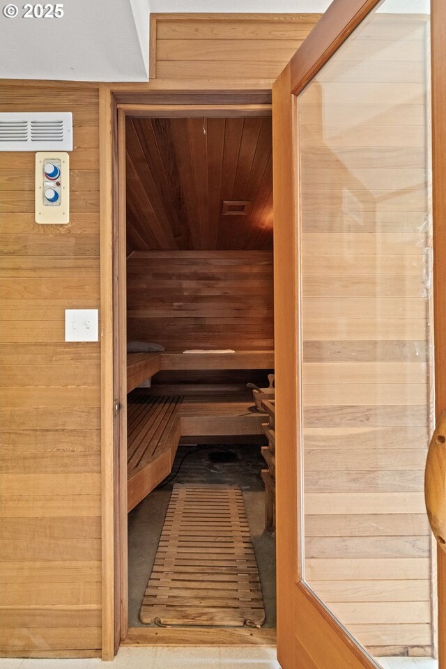 relaxing sauna featuring wood ceiling and wooden walls