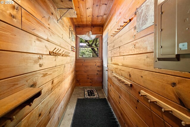 doorway to outside with wooden walls, wood ceiling, and electric panel