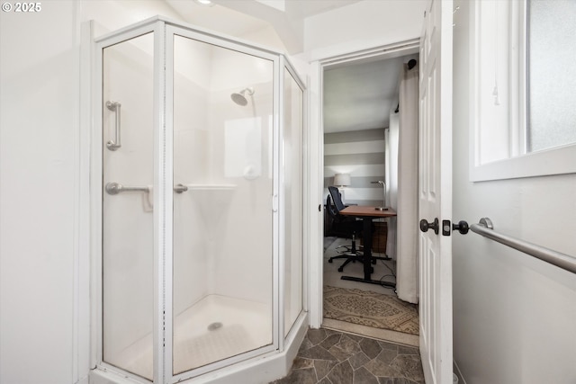 full bath featuring stone finish floor and a stall shower