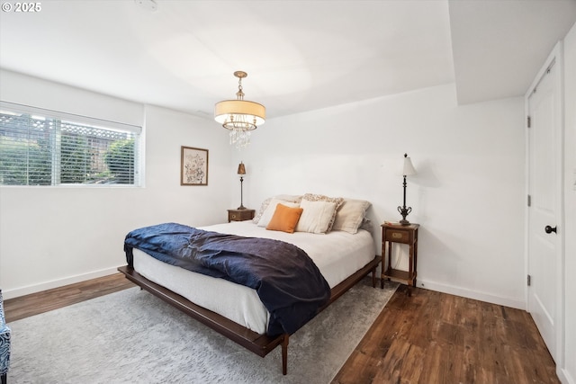 bedroom with baseboards and wood finished floors