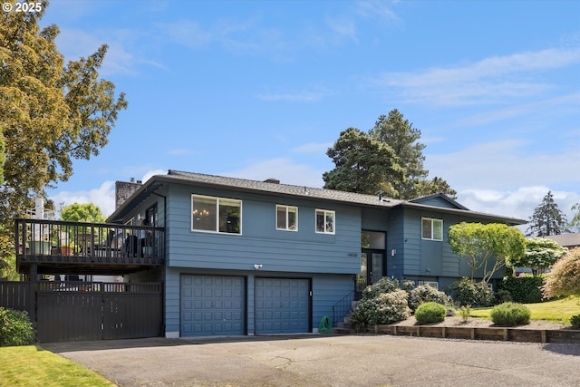 split foyer home with an attached garage, a chimney, and driveway