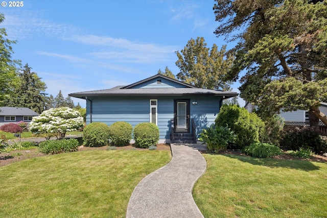 bungalow-style house featuring a front lawn and roof with shingles