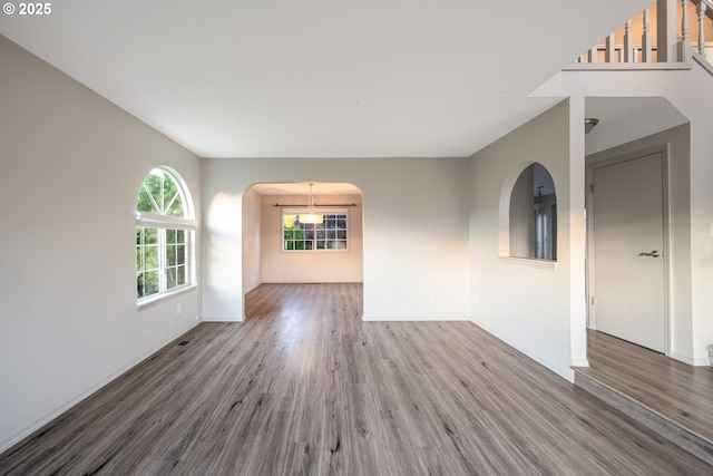 17510 NW Fieldstone Dr, Beaverton, OR 97006 - unfurnished room with wood finished floors, arched walkways, and a chandelier