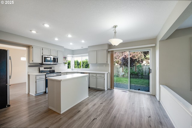 17510 NW Fieldstone Dr, Beaverton, OR 97006 - kitchen with stainless steel appliances, light countertops, recessed lighting, wood finished floors, and a center island