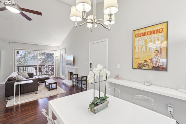 dining space featuring high vaulted ceiling, dark hardwood / wood-style floors, and ceiling fan with notable chandelier