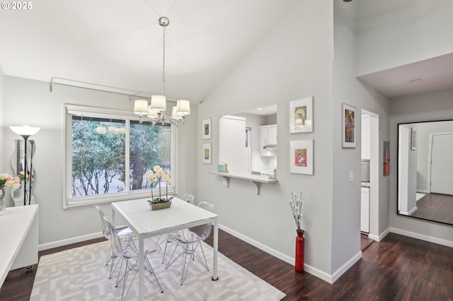 dining space featuring a chandelier, wood finished floors, baseboards, and lofted ceiling