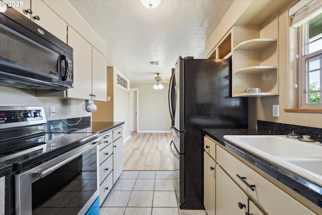 3840 Vista Dr, North Bend, OR 97459 - kitchen with stainless steel appliances, ceiling fan, dark countertops, and light tile patterned floors