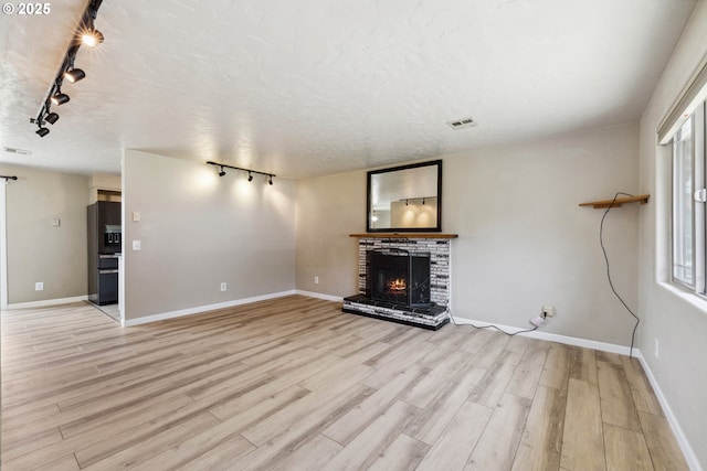 3840 Vista Dr, North Bend, OR 97459 - unfurnished living room featuring track lighting, wood finished floors, and a fireplace