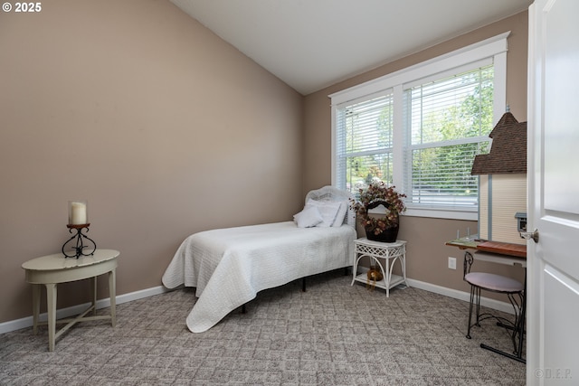bedroom featuring baseboards, multiple windows, and lofted ceiling