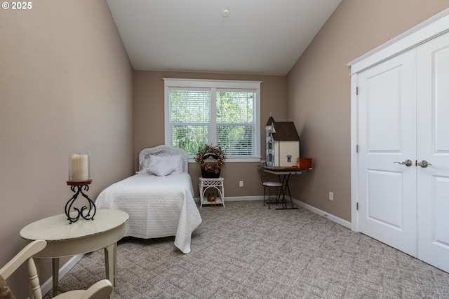 carpeted bedroom with baseboards and vaulted ceiling