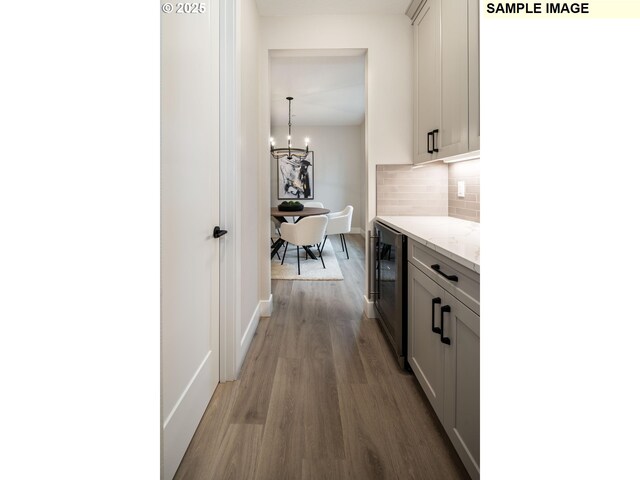1205 S Mountain Pl, Ridgefield, WA 98642 - hall featuring an inviting chandelier, beverage cooler, wood finished floors, and baseboards