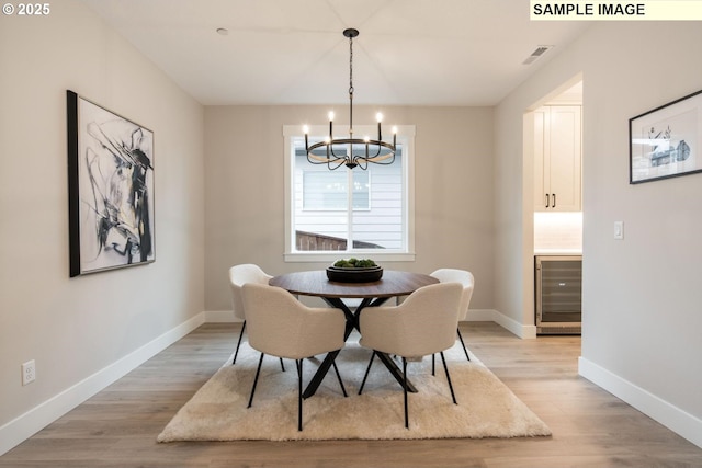 1205 S Mountain Pl, Ridgefield, WA 98642 - dining room with light wood finished floors, wine cooler, visible vents, baseboards, and a notable chandelier